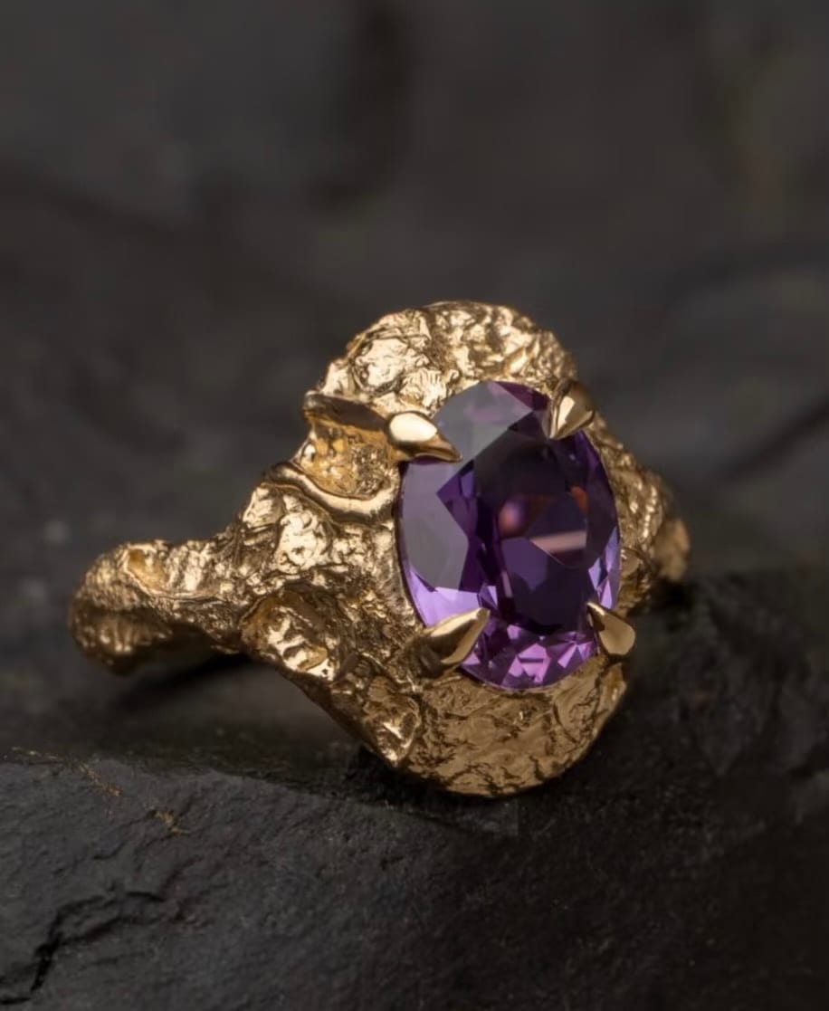 Purple oval stone in a sculpted yellow gold ring